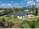 Back exterior of home showcasing the large screened in pool and mature landscaping at 130 Sylvana Ct, Auburndale, FL 33823