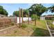 View of the home's backyard with grass, partial privacy fence, pull-up bar, and a small shed at 137 Leitha Way, Lakeland, FL 33809