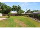 View of the home's backyard with grass, partial privacy fence, landscaping, and a small shed at 137 Leitha Way, Lakeland, FL 33809