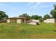 View of the home's backyard, grass, partial privacy fence, landscaping, shed, and patio at 137 Leitha Way, Lakeland, FL 33809