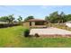 Backyard view of the home featuring a screened-in porch, patio, green grass, and a partial privacy fence at 137 Leitha Way, Lakeland, FL 33809