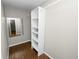 A walk-in closet features hardwood floors, mirror and a custom white shelving system for optimized storage solutions at 137 Leitha Way, Lakeland, FL 33809