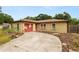 Single-story home with flamingo painted garage door; landscape with blooming plants at 137 Leitha Way, Lakeland, FL 33809