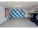 Large garage with painted accent wall, door to interior of home, laundry machines and epoxy floor at 137 Leitha Way, Lakeland, FL 33809