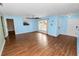 Bright living room with light blue walls, wood-look flooring, ceiling fan, and natural light at 137 Leitha Way, Lakeland, FL 33809