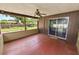 An outdoor screened porch features a ceiling fan, wood paneling, and backyard views at 137 Leitha Way, Lakeland, FL 33809