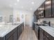 Modern kitchen with stainless steel appliances, marble countertops, and dark cabinets at 1424 Portmore Dr, Mulberry, FL 33860
