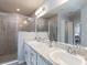 Elegant bathroom with double sinks, granite countertops, a tiled shower, and modern fixtures at 1429 Fleur Dr, Davenport, FL 33837