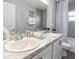 Bathroom featuring double sinks, neutral paint, decorative mirror, and tiled shower-tub combo at 1429 Fleur Dr, Davenport, FL 33837
