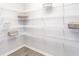 A walk-in pantry with white wire shelving, hardwood floors, and ample storage space for organization at 1429 Fleur Dr, Davenport, FL 33837