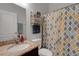 Bathroom with granite countertop, storage shelves, and patterned shower curtain at 1470 Silver Leaf Dr, Lakeland, FL 33813