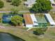 Aerial shot of community shuffleboard, tennis, and pickleball courts near a lake at 1642 Tally Ho Dr, Lakeland, FL 33810