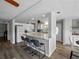 Modern kitchen with a center island, white cabinetry, and a view into the living and dining areas at 1642 Tally Ho Dr, Lakeland, FL 33810