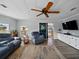 Bright living room featuring hardwood floors, a ceiling fan, and comfortable seating near a window at 1642 Tally Ho Dr, Lakeland, FL 33810