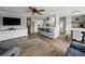 Bright living room with hardwood floors, ceiling fan, TV, and a large window to the outside at 1642 Tally Ho Dr, Lakeland, FL 33810