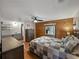 Open main bedroom featuring wood wall, ceiling fan, attached bathroom and natural light at 1642 Tally Ho Dr, Lakeland, FL 33810