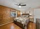 Comfortable main bedroom featuring wood wall, ceiling fan and relaxing atmosphere at 1642 Tally Ho Dr, Lakeland, FL 33810