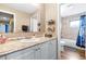 Well-lit bathroom featuring a sink with granite countertops and a shower with tiled walls at 1808 Stonecrest Ct, Lakeland, FL 33813