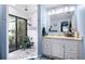 Well-lit bathroom with a walk-in shower, a white vanity, and blue accent walls at 1808 Stonecrest Ct, Lakeland, FL 33813