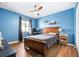 Bedroom with wood floors, ceiling fan, blue accent wall, and window offering natural light at 1808 Stonecrest Ct, Lakeland, FL 33813