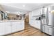 Open-concept kitchen with island and stainless refrigerator, with views of the living and dining areas at 1808 Stonecrest Ct, Lakeland, FL 33813