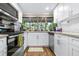 Bright kitchen features white cabinetry, stainless steel appliances, granite counters, and a garden window at 1808 Stonecrest Ct, Lakeland, FL 33813