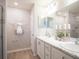 Bright bathroom featuring double sink vanity, marble counters, white cabinets, and decorative wall art at 1809 Noble Dr, Davenport, FL 33837