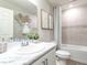 Neutral bathroom features a single sink vanity with marble countertop, shower and tub with tile surround at 1809 Noble Dr, Davenport, FL 33837