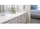 Bathroom features a double sink vanity, marble countertop, white cabinets, and a view into the bedroom at 1809 Noble Dr, Davenport, FL 33837