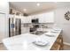 Bright kitchen features stainless steel appliances, white cabinets, and a large marble countertop with barstool seating at 1809 Noble Dr, Davenport, FL 33837