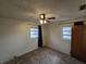 Bedroom featuring wall to wall carpet, ceiling fan and two windows with dark curtains at 1809 Optimist Dr, Lakeland, FL 33801