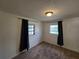 Cozy bedroom with plush carpet, two windows with dark curtains, and a standard ceiling light fixture at 1809 Optimist Dr, Lakeland, FL 33801