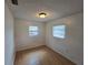 Bedroom featuring light hardwood floors, a standard ceiling light fixture, and two windows at 1809 Optimist Dr, Lakeland, FL 33801