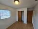 Bedroom with light hardwood floors, a single window with blinds and a standard closet with sliding doors at 1809 Optimist Dr, Lakeland, FL 33801