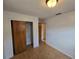 Bedroom featuring light hardwood floors, standard closet with sliding doors, and view to adjacent room at 1809 Optimist Dr, Lakeland, FL 33801