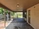 Covered carport featuring concrete flooring, chain-link fence, providing sheltered parking and storage at 1809 Optimist Dr, Lakeland, FL 33801