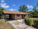 Exterior shot showing the driveway, carport, and attractive front entrance of this appealing home at 1809 Optimist Dr, Lakeland, FL 33801