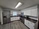 Bright kitchen with stainless steel appliances, white cabinetry, and durable laminate floors at 1809 Optimist Dr, Lakeland, FL 33801
