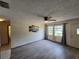 Bright living room featuring wood-look flooring, a ceiling fan, and natural light from the large window at 1809 Optimist Dr, Lakeland, FL 33801