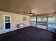 Enclosed porch with swing, concrete flooring, and bright windows, offering a relaxing outdoor area at 1809 Optimist Dr, Lakeland, FL 33801