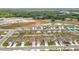 An aerial view shows a neighborhood with modern homes, green lawns, and a pond at 1821 Thompson Preserve Boulevard, Bartow, FL 33830