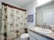 Bathroom with a palm tree shower curtain, a framed picture and a granite vanity at 1821 Thompson Preserve Boulevard, Bartow, FL 33830