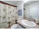 Bathroom with a palm tree shower curtain, a framed picture and a granite vanity at 1821 Thompson Preserve Boulevard, Bartow, FL 33830
