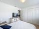 Bright bedroom featuring a bed, dresser with television, and a closet, all in neutral tones at 1821 Thompson Preserve Boulevard, Bartow, FL 33830
