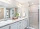 Well-lit bathroom with double sinks, vanity, shower and tub showcasing modern fixtures and a neutral color palette at 1837 Noble Dr, Davenport, FL 33837