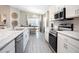 Bright, open kitchen with stainless steel appliances, quartz countertops, and eat-in dining area at 1837 Noble Dr, Davenport, FL 33837