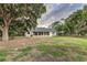Back exterior view of property with a long screened porch and large yard with mature trees at 2070 W Lake Hamilton Dr, Winter Haven, FL 33881