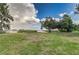 Expansive backyard with mature trees, leading to a tranquil lake, offering privacy and scenic views at 2070 W Lake Hamilton Dr, Winter Haven, FL 33881