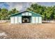 Well-maintained barn with white and teal trim and a spacious interior at 2070 W Lake Hamilton Dr, Winter Haven, FL 33881