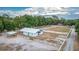 Aerial view of horse barn and paddock surrounded by a white fence at 2070 W Lake Hamilton Dr, Winter Haven, FL 33881